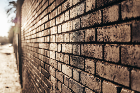 Brick wall background at sunset with sun rays, stone texture.の写真素材