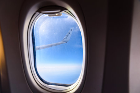 Valencia, Spain - March 8, 2019: Flaps of an Ryanair airplane seen from inside during a flight over the clouds of the sky.のeditorial素材