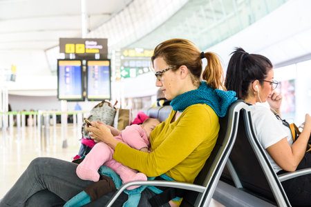 Valencia, Spain - March 8, 2019: Mother and baby passengers waiting to take their plane during a trip.のeditorial素材