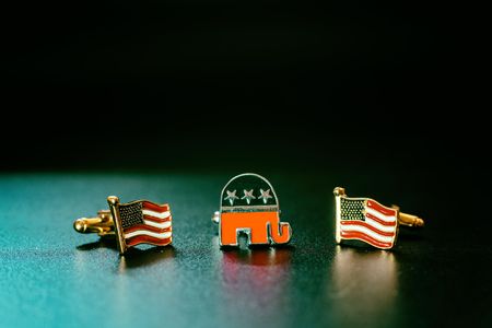 Emblem of the american republican party, an elephant, between two flags USA, isolated on black background.の写真素材