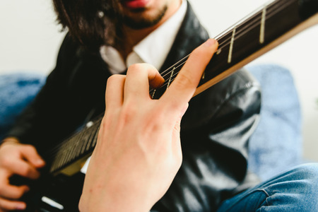 Detail of the fingers of a guitarist placed on the fret of the mast of the guitar playing a chord doing Tapping.の写真素材