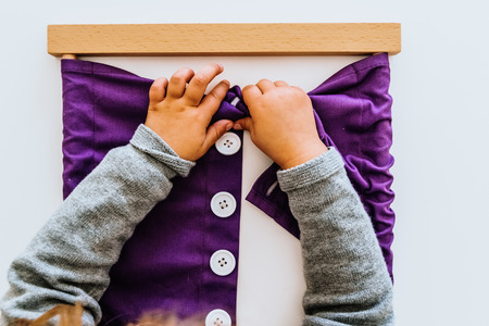 Hand of a student handling montessori material inside a classroom.の写真素材