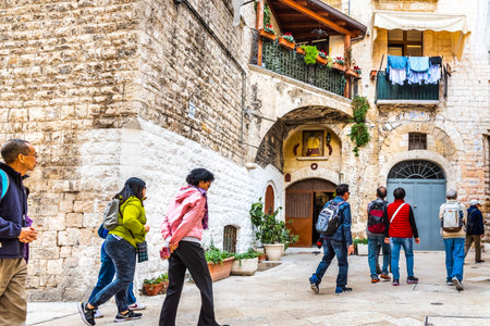Bari, Italy - March 12, 2019: Asian tourists from China strolling through the Italian city.のeditorial素材