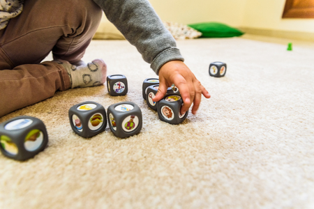 Little girl playing with a children's toy dice.の写真素材