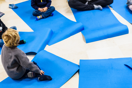 Group of children doing yoga exercises and relaxing on some mat.の写真素材