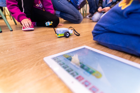 Valencia, Spain - April 13, 2019: Children using a robot motorized, reconfigurable education toy, created with Lego WeDo blocks programmable through a tablet or mobile.のeditorial素材