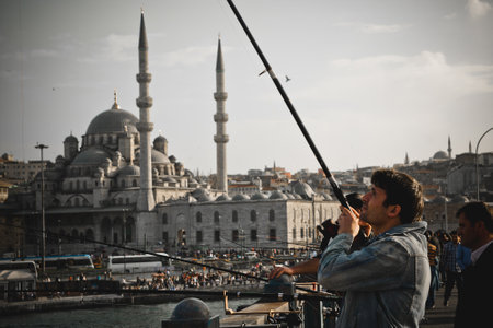 Istanbul, Turkey - April 8, 2012: Turkish fishermen with rod on the Galata Bridge.のeditorial素材