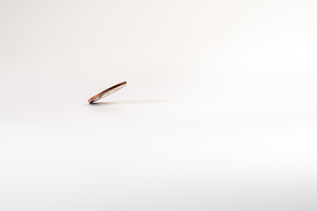 Dollar coin rotating on white background, concept of American economy.の写真素材