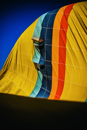 Detail of multicolored fabric of a hot air balloon deflating, vertical image.の写真素材