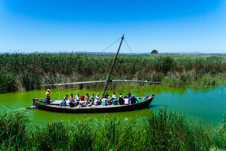 Valencia, Spain - June 2, 2019: Tourists sailing on a touristic tour in a traditional boat on the Albufera lake in Valencia on a sunny dayのeditorial素材