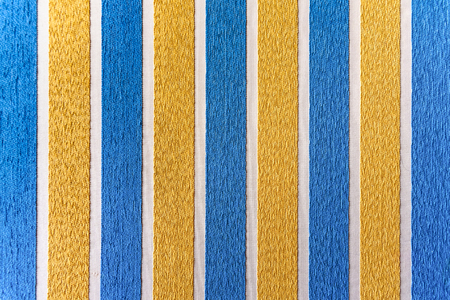 Strips of colored fabric cover a wall of carpet, decoration background.の写真素材