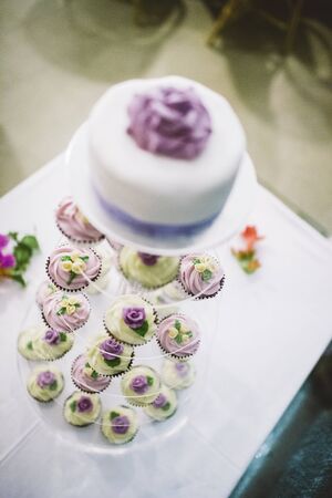 Desserts and wedding cake with very sweet cupcakes at an event.の写真素材