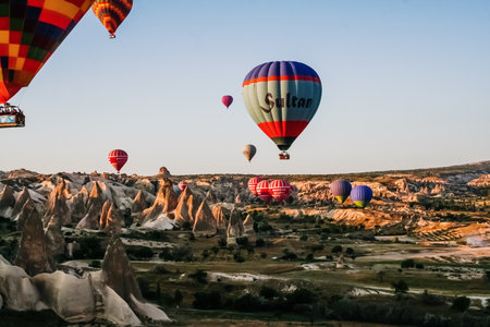 Goreme, Turkey - June 14, 2019: Travelers and tourists flying over mountains at sunset in a colorful aerostat balloon in Goreme, the Turkish cappadocia.のeditorial素材