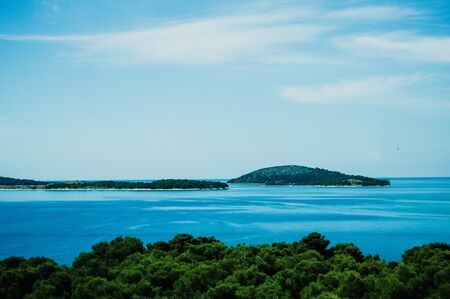 Croatian coast with islets and blue sky.の写真素材