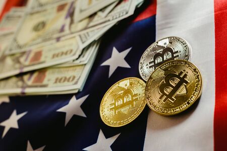 Bitcoins and 100 dollar bills with american flag background.の写真素材