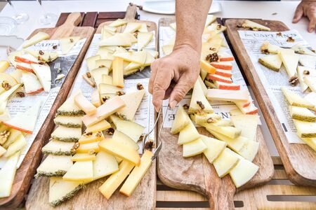 Commensal serving some pieces of cured cheese during an event in a restaurant.