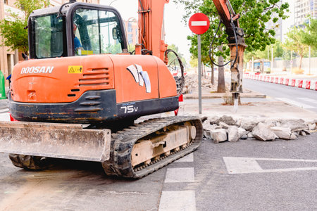 Valencia, Spain - July 2, 2019: Operator drives a pneumatic hammer to break the pavement of a street to repair it.のeditorial素材