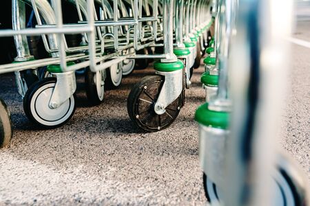 Detail of the plastic wheels of shopping carts in a supermarket lined up.の写真素材