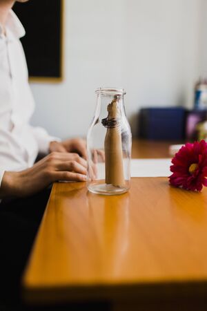 Elegant man knots a roll of paper with a message to put it in a bottle.の写真素材
