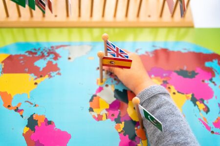 Girl placing flags of Europe and Spain on a mapの写真素材