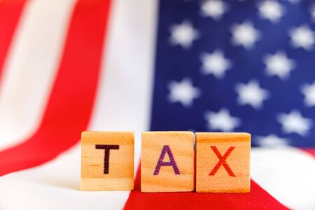 Tax day written with wooden letters to indicate the day of payment of taxes in america.