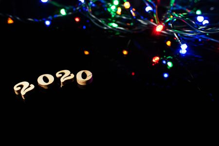 New year 2020 with numbers and bright lights on dark background and free space for text.の写真素材