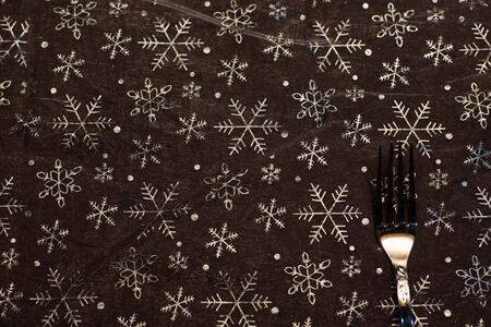 Tablecloth background with Christmas motifs and cutlery.