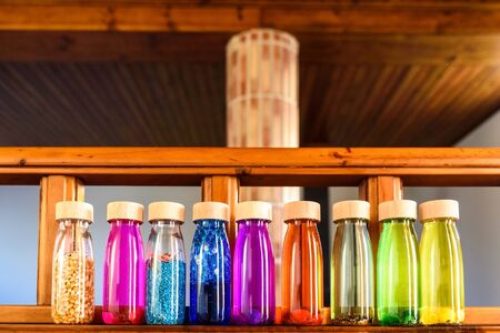 Collection of bottles of calm, plastic with wooden stopper, toy filled with liquids and materials of bright colors and glitter to relax children when they are nervous.の写真素材