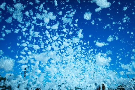 Many white soap bubbles flying across the sky.の写真素材