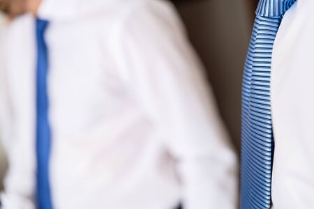 Detail of two businessmen with unfocused background, white shirts and blue ties and...の写真素材