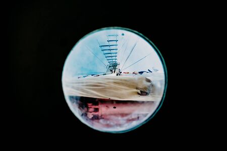 Ship moored to port seen through from inside the porthole of a ship.