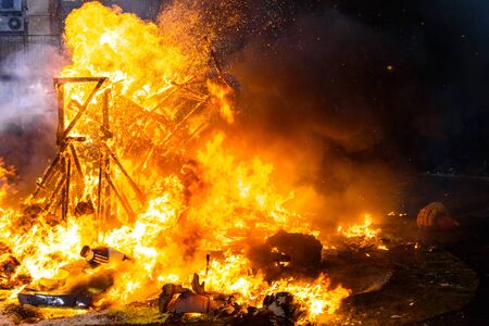 Detail of a Falla Valenciana burning between flames of fire.の写真素材