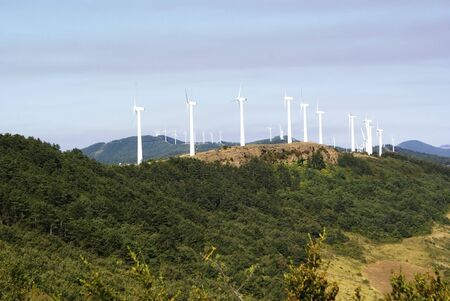 White windmills to generate electricity on top of a hill in Navarra, Spain.
