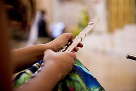 Flute player holding a metal transverse flute in his hands.の写真素材