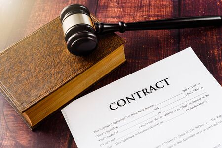 Gavel on the law books that regulate paper contracts to do business.の写真素材