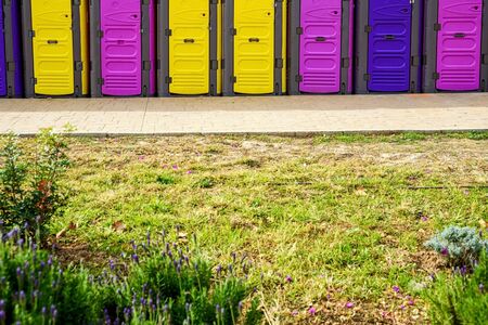 Portable chemical toilets of bright colors placed for an event on the streets of the city.の写真素材