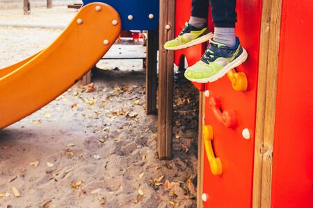 Feet hanging as a child playing in a playground.の写真素材