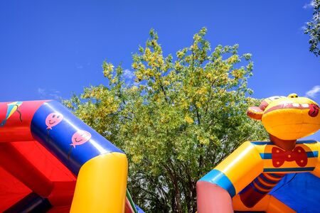 Colorful inflatable castles for children to jump and bounce in an amusement park.の素材 [FY310135670888]