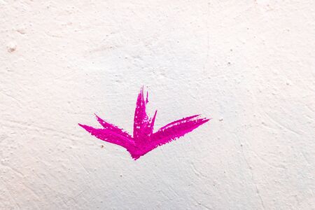Lonely pink flower painted on a white wall.