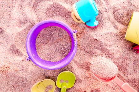 Plastic toy buckets and shovels in a sandboxの写真素材