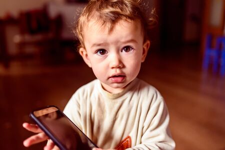 Girl in pajamas with mobile phone.の写真素材