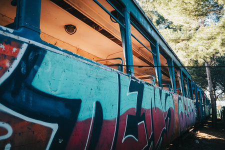 Old tram abandoned and vandalized in a park by young graffiti artists.のeditorial素材