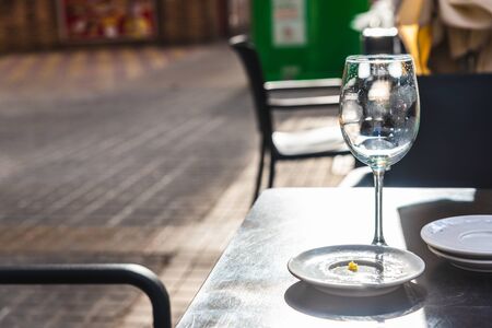 Empty glass of beer that a bar customer leaves abandoned on the terrace of a street without paying.の写真素材