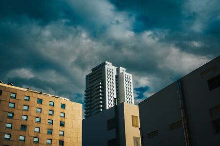 Block of tall residential buildings with clouds in the background at sunset sun.の写真素材
