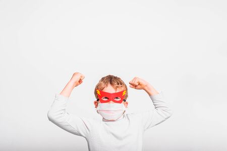 A boy with a fun superhero mask to protect himself from the viral infections of the disease.の写真素材