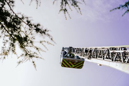 Mechanical ladder of firefighters seen from below with blue sky in the background.の写真素材