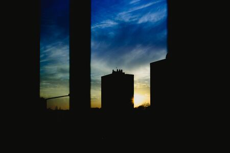 Sunset view from the window of a building, warm and melancholic atmosphere with cloud background.の写真素材