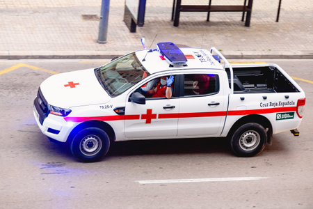 Valencia, Spain - April 10, 2020: Health members of the Spanish Red Cross greet the homebound population from the street during the covid-19 pandemic.のeditorial素材