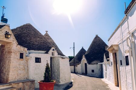 Houses of the tourist and famous Italian city of Alberobello, with its typical white walls and trulli conical roofs.の写真素材