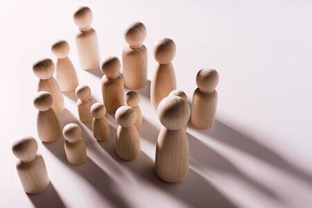 Figures in the shape of people casting shadows on a flat surface.